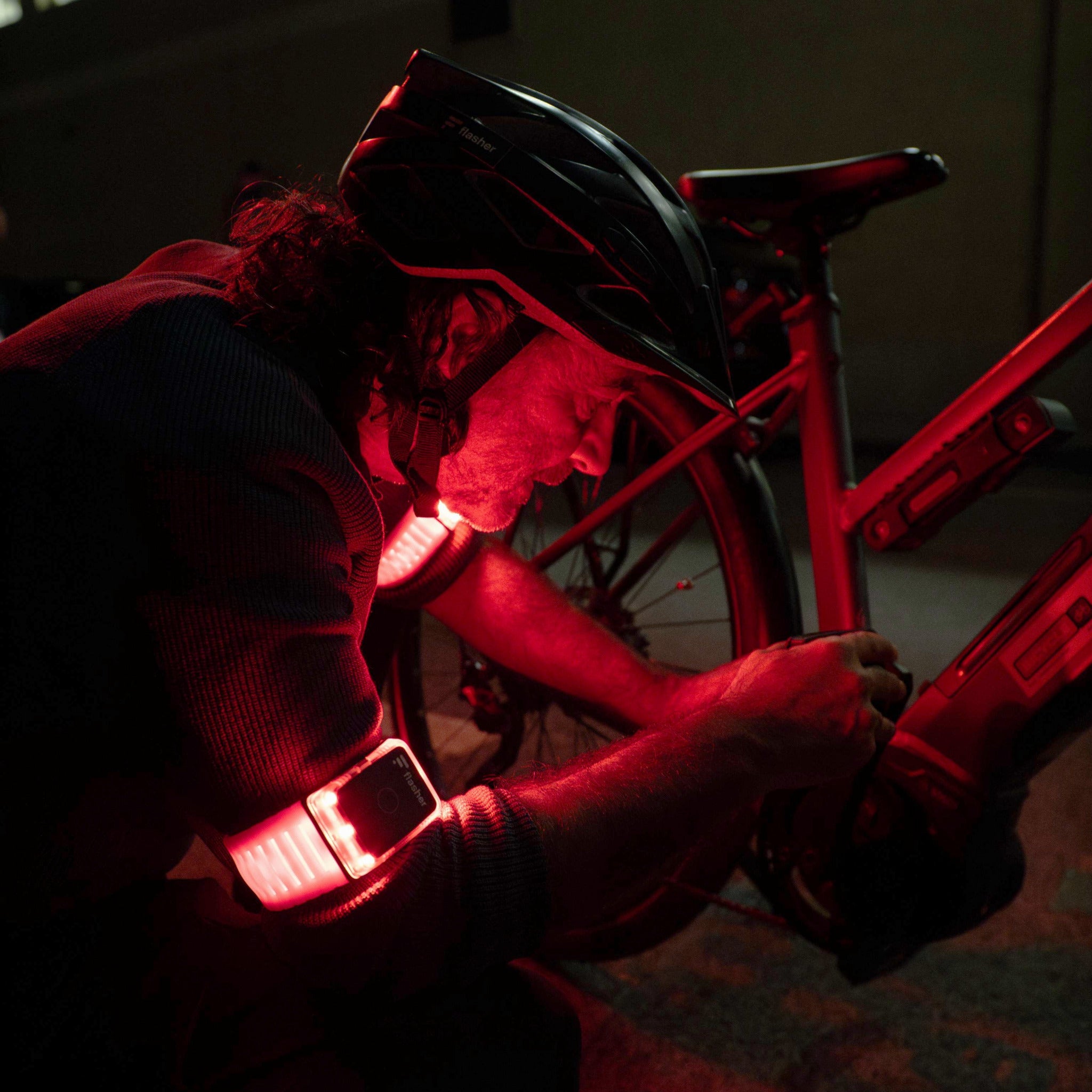 rot leuchtender Flasher Notfallmodus abends: Mann repariert Fahrradpedal