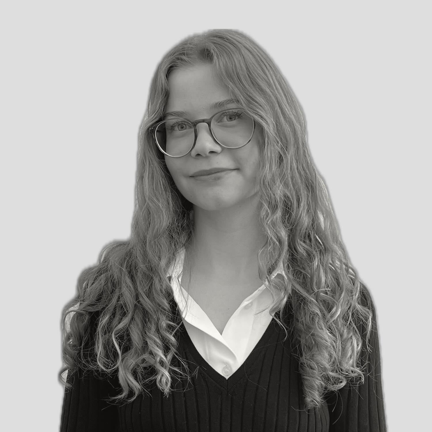 Schwarz-weiß Foto von Sarah Unger, einer jungen Frau die Lächelt und unseren Kundensupport macht.
