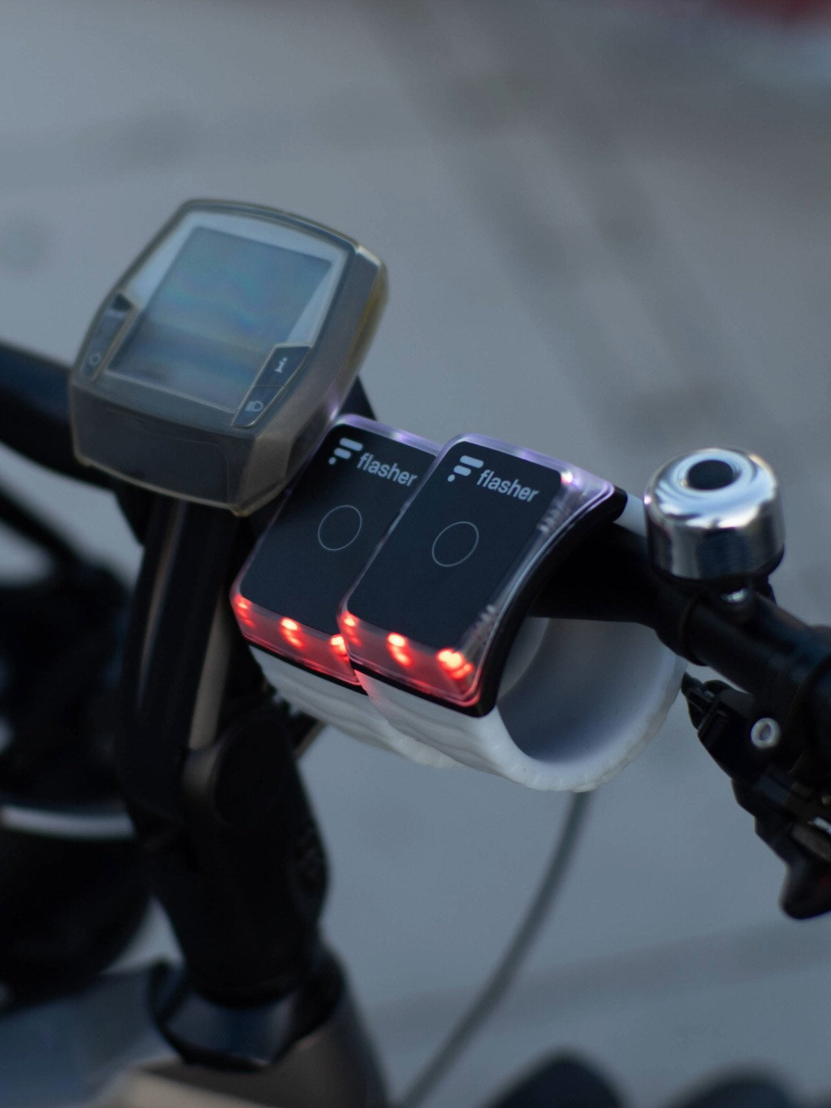 Zwei Flasher Armbänder am Fahrradlenker eines E-Bike.