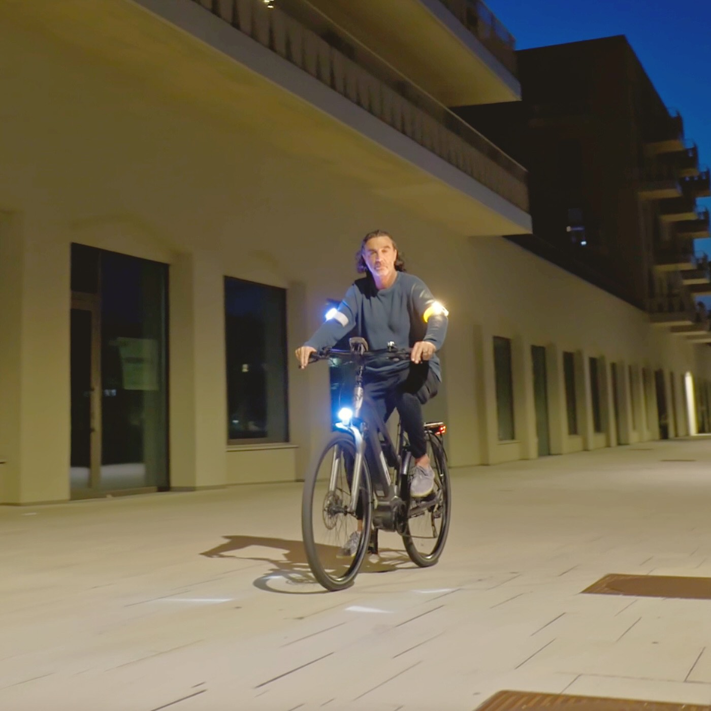 Radfahrer am Abend, heller gelber Blinker am Arm.