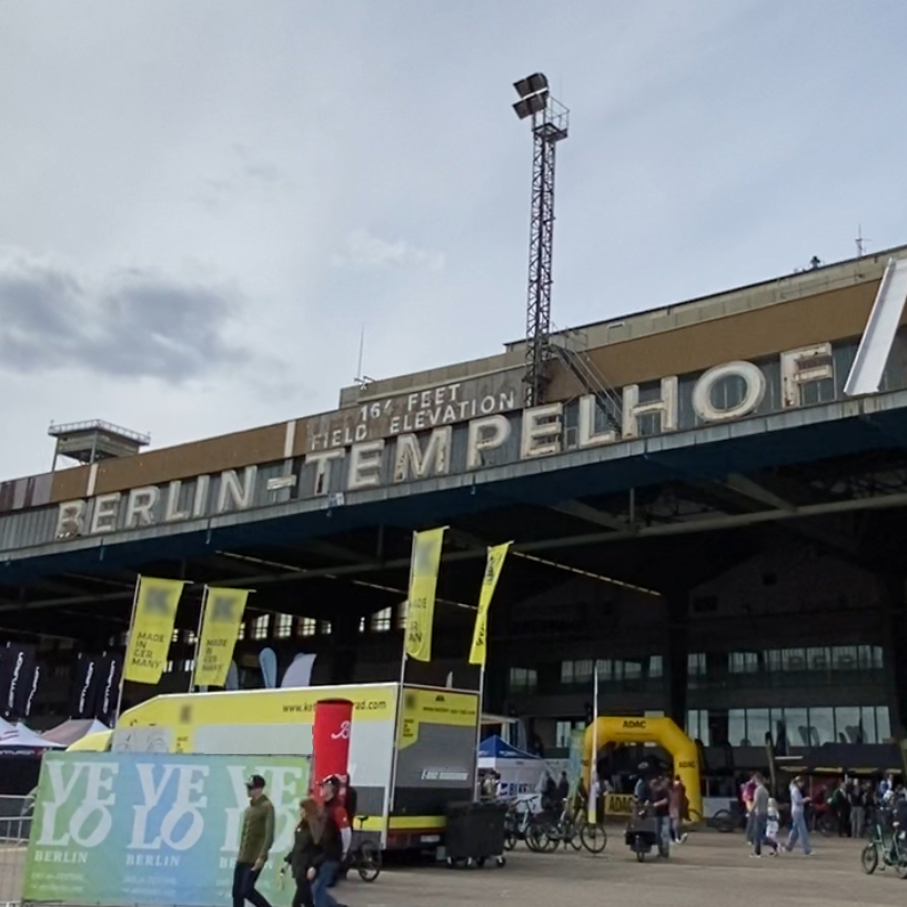 Die Schriftzeichen das alten Flughafens Berlin-Tempelhof mit zahlreichen Messeständen von Fahrradmarken darunter.