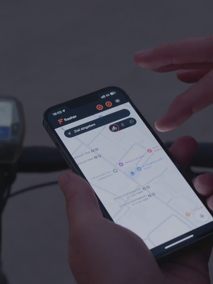 Radfahrer wählt Route in der Flasher App aus, steckt Telefon ein und fährt los. Vibration im rechten Armband.