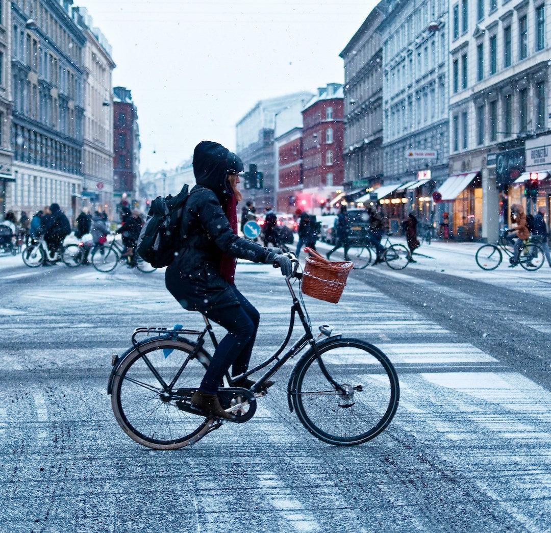 Radfahrerin auf schneebedeckter Straße in der Stadt.